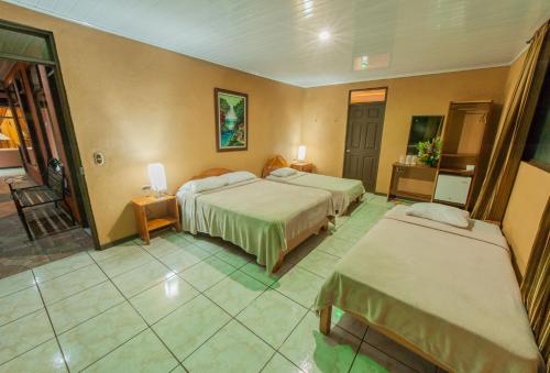 a hotel room with two beds and a balcony at Cabinas Eddy B&B in Monteverde Costa Rica