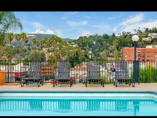 a group of chairs sitting next to a swimming pool at 2BR Hollywood Apt with Rooftop Pool & Stunning Views in Los Angeles