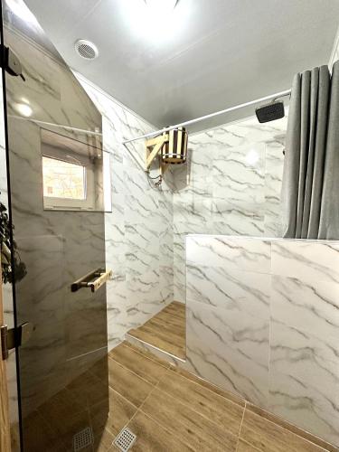 a bathroom with a shower with a glass door at Дом в Бурабай in Borovoye
