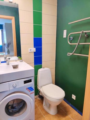 a bathroom with a toilet and a washing machine at Dunes Trail 2 in Melnragė