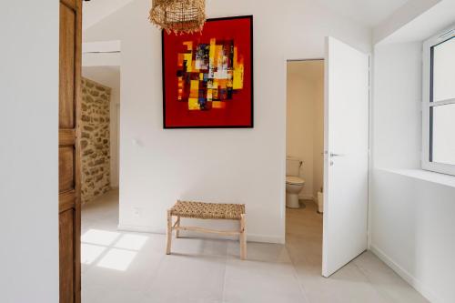 une chambre avec un banc et un tableau sur le mur dans l'établissement Entre Terre & Sel Maison de Charme Marais Salants, à Guérande