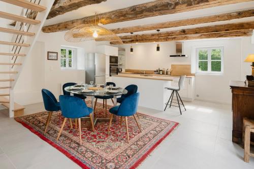 une cuisine et une salle à manger avec une table et des chaises bleues dans l'établissement Entre Terre & Sel Maison de Charme Marais Salants, à Guérande