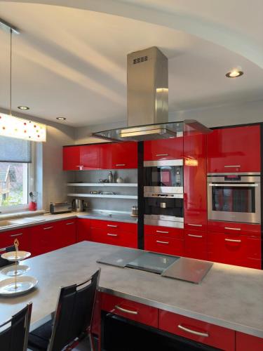 a kitchen with red cabinets and a table with chairs at Elysium Estate Szekszárd in Szekszárd