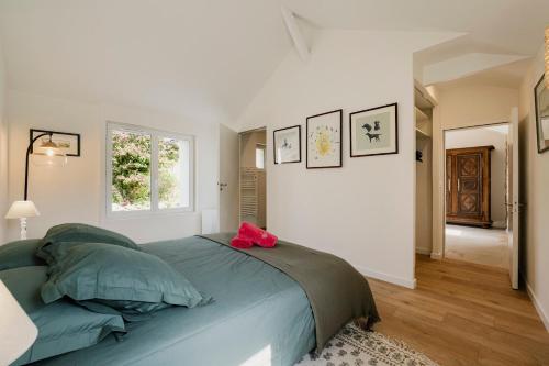 - une chambre avec un lit doté d'un oreiller rose dans l'établissement Entre Terre & Sel Maison de Charme Marais Salants, à Guérande