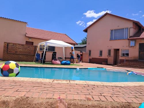 a person standing next to a swimming pool with a ball at Hideaway in Roodepoort