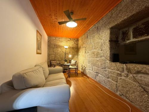 a living room with a couch and a ceiling fan at Casa dos Antunes in Terras de Bouro