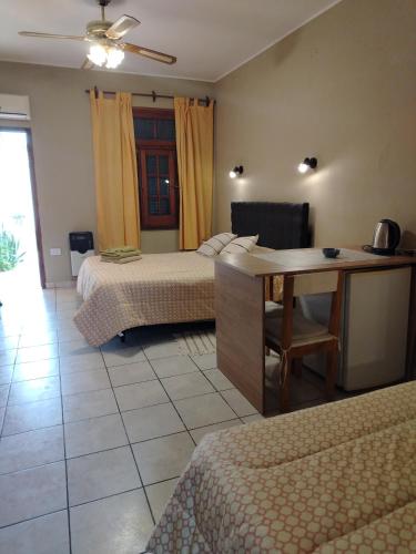 a bedroom with two beds and a desk with a table at Departamentos Centro in Villa Dolores