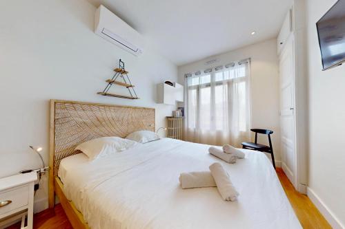 une chambre avec un grand lit blanc avec des serviettes dessus dans l'établissement Le Chapuisien - 4 étoiles vielle ville et lac, à Annecy