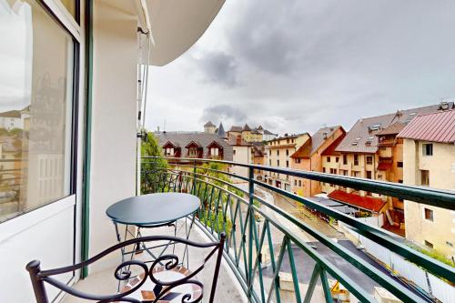 d'un balcon avec une chaise et une vue sur la ville. dans l'établissement Le Chapuisien - 4 étoiles vielle ville et lac, à Annecy