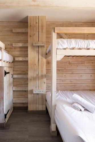 two bunk beds in a room with wooden walls at Alberg Taull in Taull