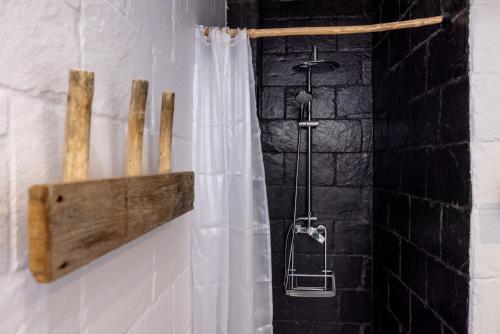 a shower with a white shower curtain on a wall at Alberg Taull in Taull