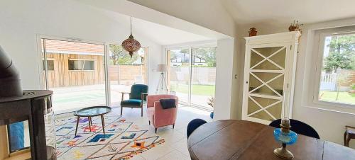 un salon avec une table et des chaises en bois dans l'établissement Villa Côte Ouest, Elégance Piscine et Pool-House, à Gujan-Mestras