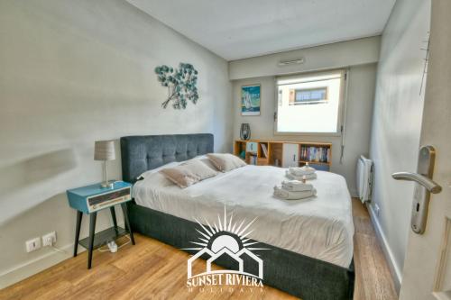 une chambre avec un grand lit avec une tête de lit bleue dans l'établissement LE PATIO VAUBAN Airco Garage for 4 by SUNSET, à Antibes