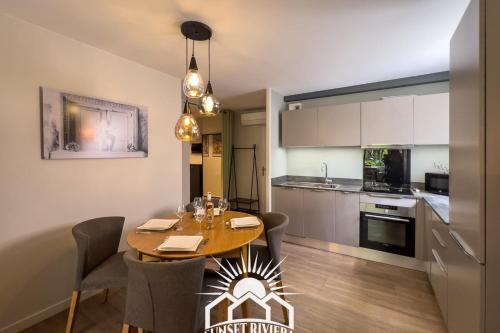 une cuisine et une salle à manger avec une table et des chaises dans l'établissement LE PATIO VAUBAN Airco Garage for 4 by SUNSET, à Antibes