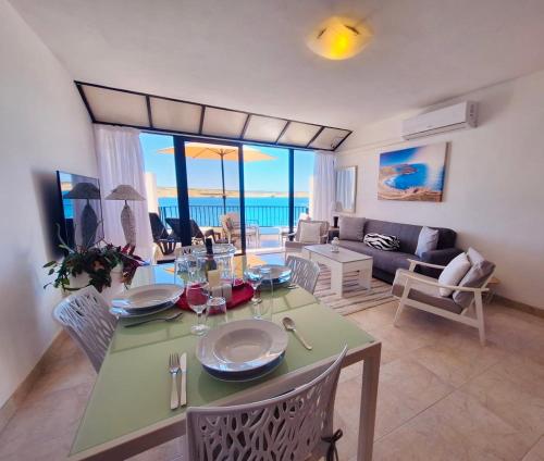 a living room with a green table and chairs at Seafront apartment Terrace, lounger & Panoramic ocean views in Mellieħa