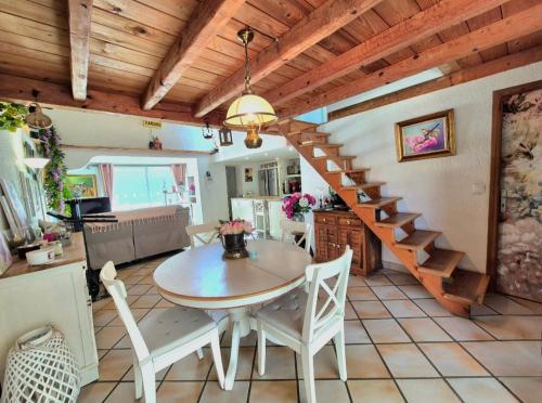 une cuisine et une salle à manger avec une table et un escalier dans l'établissement La Bergerie, maison T3 avec Piscine, à Sanary-sur-Mer