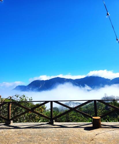 a view from the top of a mountain with clouds at @cabanasdobarao, Pedra do Baú in São Bento do Sapucaí