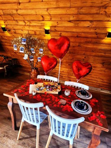 a table with red hearts on the wall and a table with food at @cabanasdobarao, Pedra do Baú in São Bento do Sapucaí