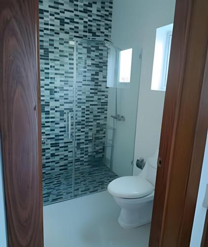 a bathroom with a toilet and a glass shower at Luz María Piscina y PlayaVilla en Plantación in Muñoz