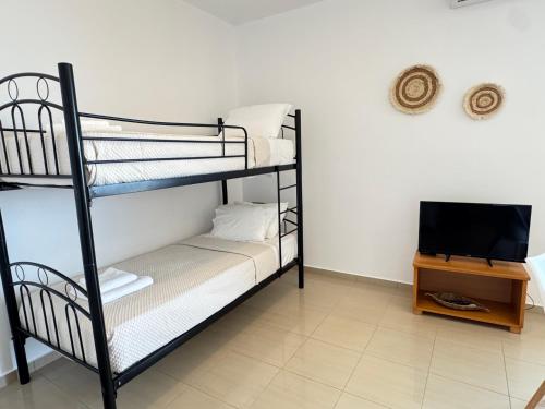 a room with two bunk beds and a television at Pachia Ammos Falasarna in Falasarna