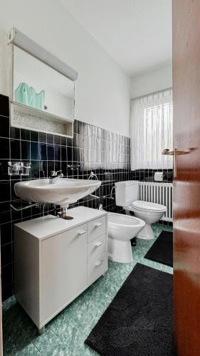 a bathroom with a sink and a toilet and a mirror at Ca' Cagiallo - Apartment in Capriasca in Tesserete