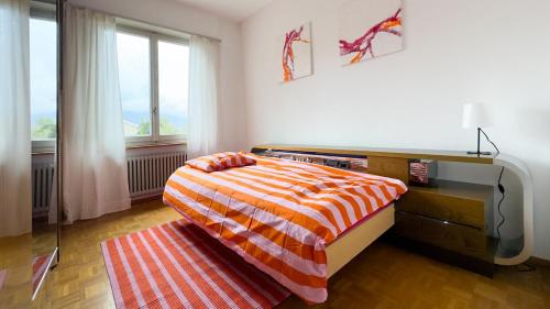 a bedroom with a bed and a desk and a window at Ca' Cagiallo - Apartment in Capriasca in Tesserete