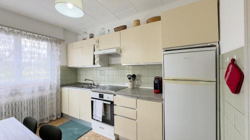 a small kitchen with white cabinets and a refrigerator at Ca' Cagiallo - Apartment in Capriasca in Tesserete