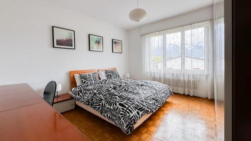 a bedroom with a bed and a large window at Ca' Cagiallo - Apartment in Capriasca in Tesserete