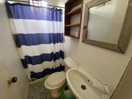 a bathroom with a toilet and a sink and a mirror at Casa de Playa Manecal in Coveñas