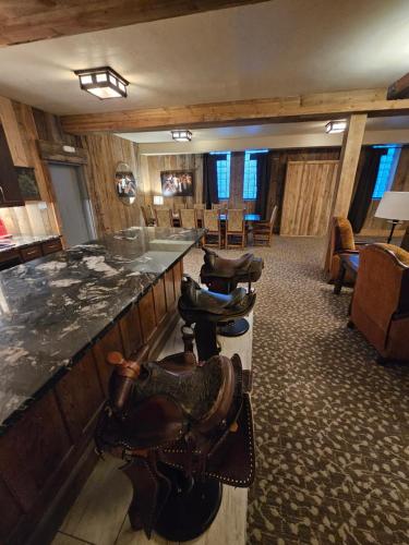 a bar in a lodge with chairs and tables at Eaglescape Suites and Event Center in Miles City