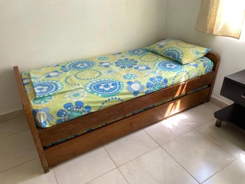 a bed with a blue and white comforter on it at Casa de Playa Manecal in Coveñas