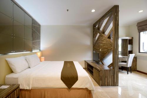 a bedroom with a large bed and a staircase at Midtown Residence Simatupang Jakarta in Jakarta
