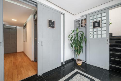 a hallway with a door and a potted plant at Senda Stays Condesa in Mexico City
