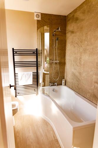 a bathroom with a tub and a shower and a toilet at Spacious 4Bed Parking & Wi-Fi - Contractor Stays in Pallion