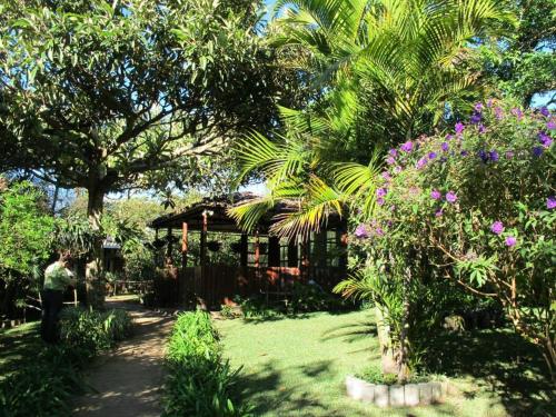 a woman standing in the yard of a garden at Cabañas los Lirios de Apaneca in Apaneca