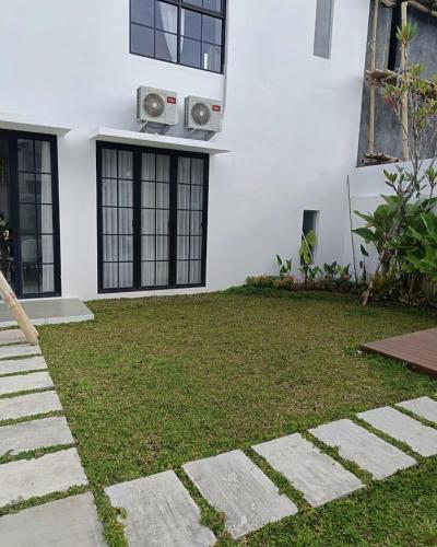 a house with a lawn in front of it at JessAble Home Stay in Manado