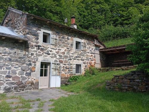 an old stone house with a white door at Maison de campagne in Montusclat