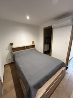 une chambre avec un grand lit dans une pièce dans l'établissement maison tranquille, à Beaupouyet