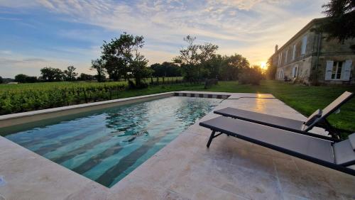 - une piscine avec banc à côté d'un bâtiment dans l'établissement La Maison du Séguy, à Saint-Ciers-de-Canesse