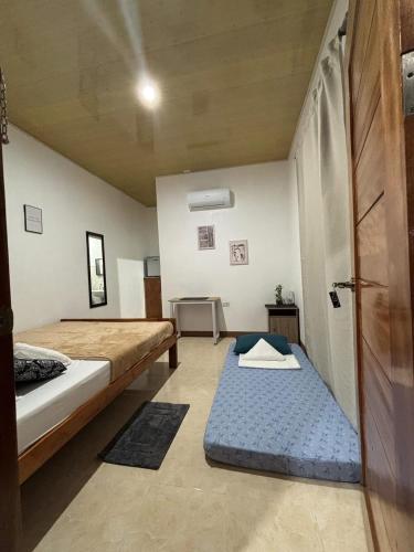 a room with two beds and a door with a mattress at Felomina Guesthouse in San Juan