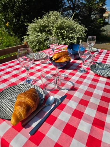une table à damiers rouge et blanc avec des verres et du pain dans l'établissement La maison des lavandes, à Cléon-dʼAndran