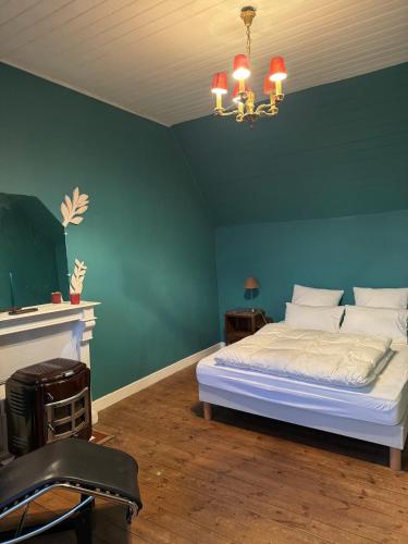 una camera da letto con un letto e una parete verde di Les perdrix a Penmarch
