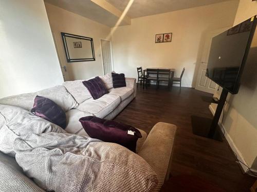 a living room with a couch and a flat screen tv at Lovely home in Manchester in Manchester