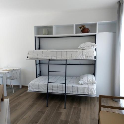 two bunk beds in a room with a table at Suite Valmarecchia in Pietracuta