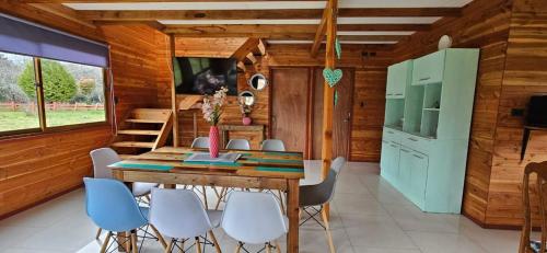 a dining room with a table and chairs at Cabaña Lafken in Coñaripe
