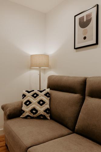 a brown couch in a living room with a lamp at Logroño Urban Home in Logroño