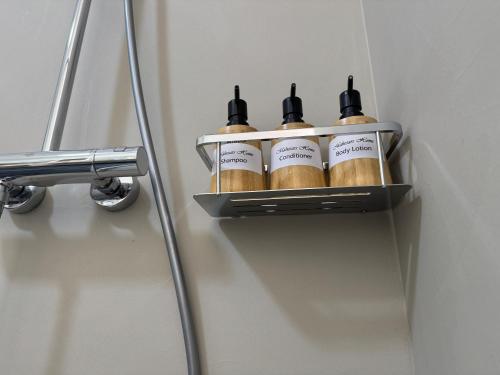 a rack with four bottles of soap on a wall at Mahesars Home in Gevelsberg