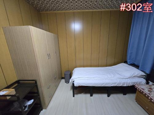 a small room with two beds and a cabinet at 高鐵中彰309民宿 in Changhua City