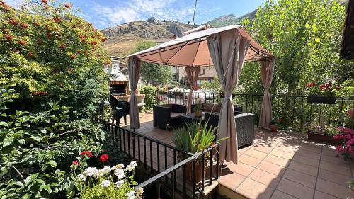 un patio con cenador y algunas flores en El Hayedo de Argovejo, en Argovejo