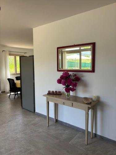 une pièce avec une table avec un vase de fleurs dessus dans l'établissement 